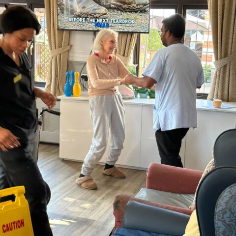 Resident dancing with a member of the care team in the lounge