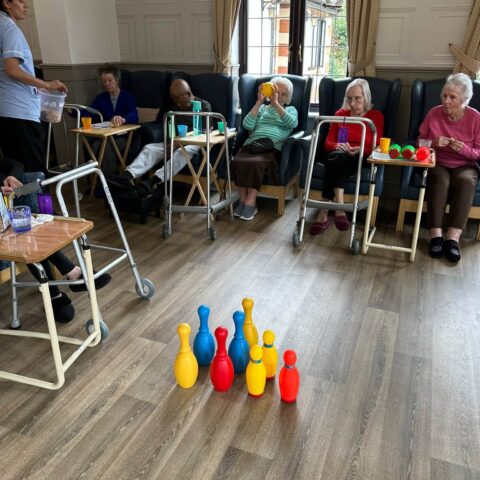 Residents taking part in a colourful indoor bowling activity