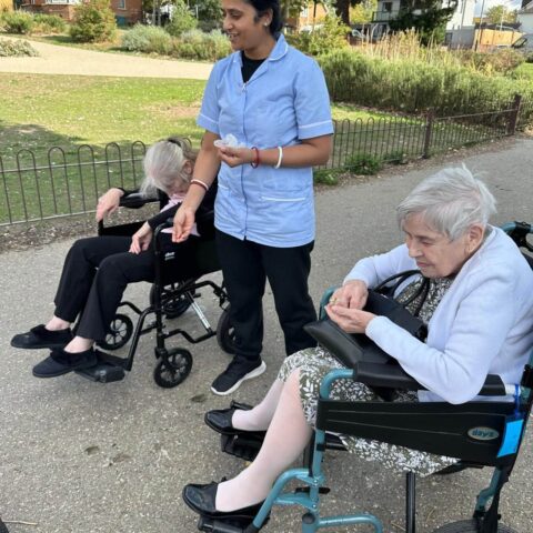 Residents with a care team member enjoying a bird-feeding outing in the park