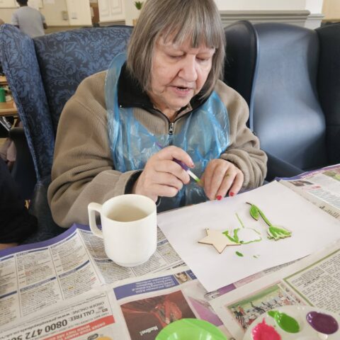 Resident painting during an arts and crafts activity at Nightingale Care Home