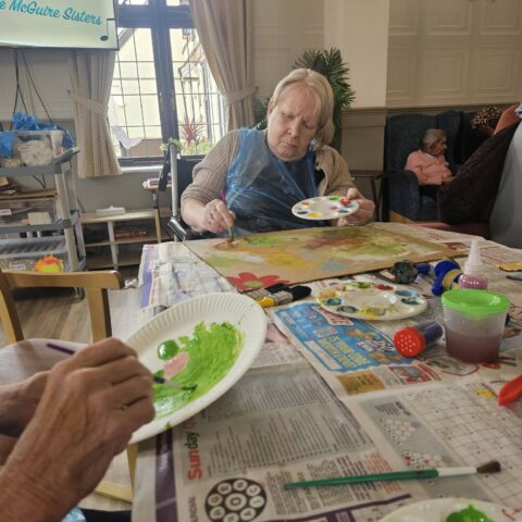 Residents enjoying arts and crafts followed by pet therapy with Lance at Nightingale Care Home