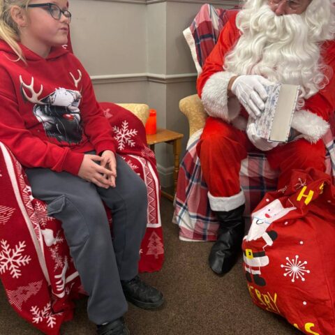 Resident seated beside Santa during a Christmas visit