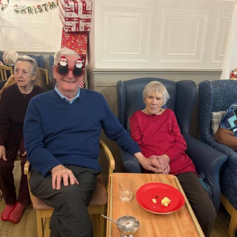 Residents seated together wearing festive Christmas hats