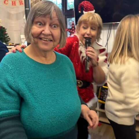 Residents smiling and singing together during the Christmas party