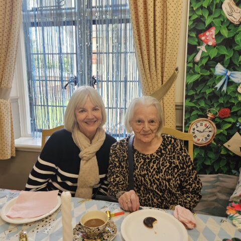 Residents, staff and family members enjoying the Mad Hatter’s Tea Party at Nightingale House