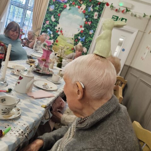 Residents, staff and family members enjoying the Mad Hatter’s Tea Party at Nightingale House