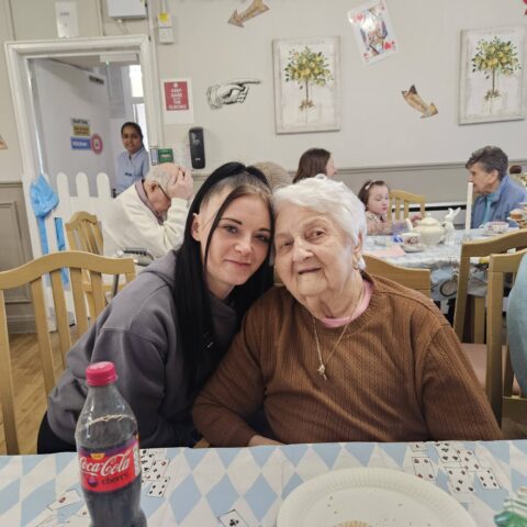 Residents, staff and family members enjoying the Mad Hatter’s Tea Party at Nightingale House