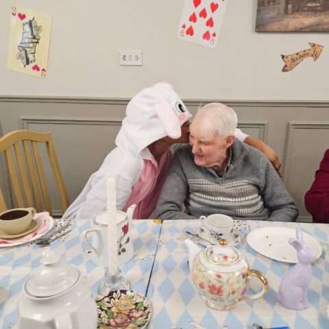 Residents, staff and family members enjoying the Mad Hatter’s Tea Party at Nightingale House