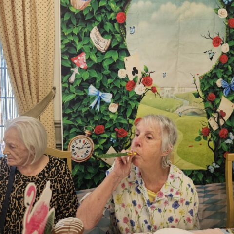 Residents, staff and family members enjoying the Mad Hatter’s Tea Party at Nightingale House