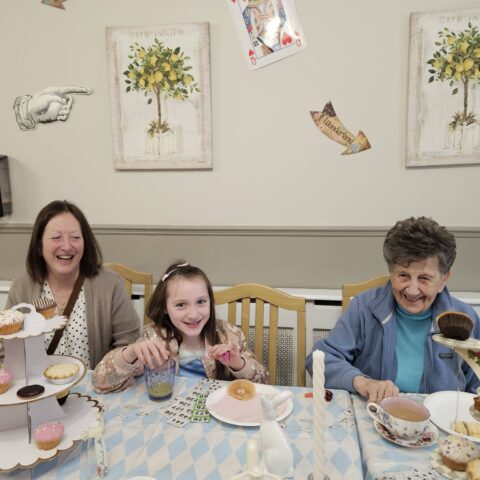 Residents, staff and family members enjoying the Mad Hatter’s Tea Party at Nightingale House