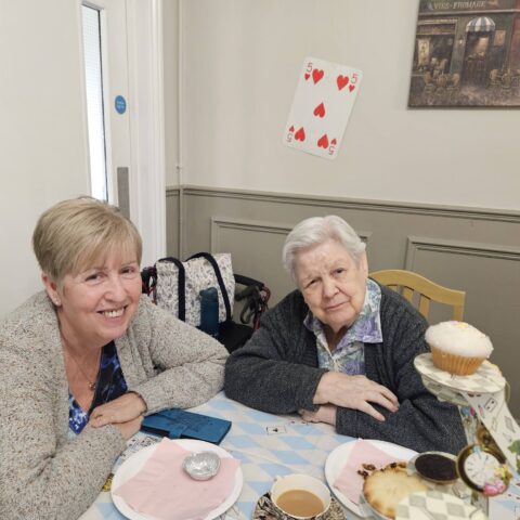 Residents, staff and family members enjoying the Mad Hatter’s Tea Party at Nightingale House
