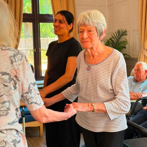 Residents taking part in a social activity together with a care team member